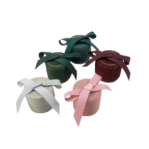 Elegant velvet round jewelry box set with ribbon bows and golden stitching details