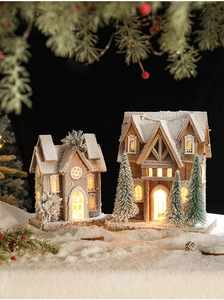 Détail de petites maisons de Noël en bois illuminées avec effet de neige poudrée