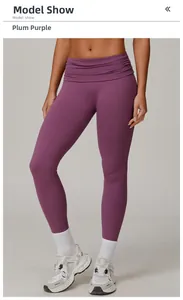 Detail of high-waisted prune purple yoga pants with pleated waistband and matte texture