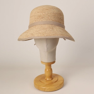 Detailed close-up of woven raffia straw texture and elegant bow ribbon on sun hat
