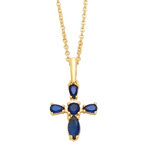 Golden cross necklace with blue teardrop gemstones on a white background