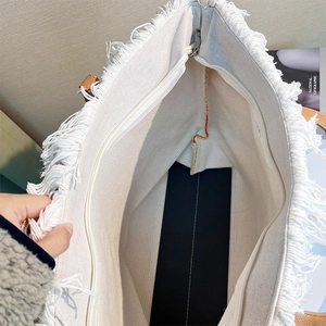 Detail showing inner zipper closure and spacious interior of the tassel canvas tote bag