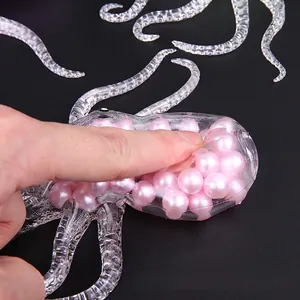Pink octopus stress ball fidget toy with squishy pearl beads on black background