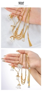 Detail of vintage gold flower pendant with tassel and zircon snake chain necklace