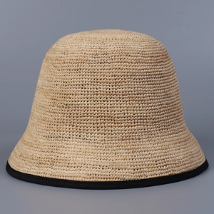 Detailed view of the fine straw weave texture and black ribbon edging on a bucket hat
