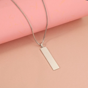 Macro detail of polished stainless steel rectangular pendant on a fine box chain