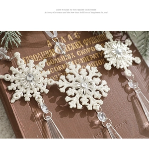 Close-up of sparkling acrylic snowflakes with drop pendants on a vintage book