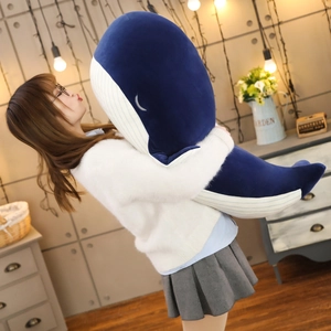 Large blue whale plush toy hugged by a person for size demonstration