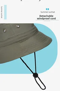 Détail de chapeau de soleil vert armée avec œillets d'aération et cordon coupe-vent