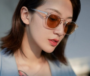 Close-up of stylish round jelly sunglasses with orange lenses on model side profile