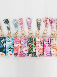Variety of floral print PU leather card holders with tassels and gold hardware on white back