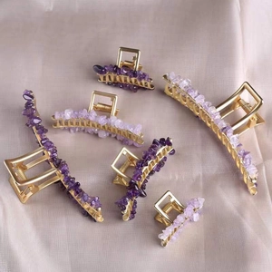 Detailed view of six gold alloy hair claws featuring assorted raw purple crystal stones