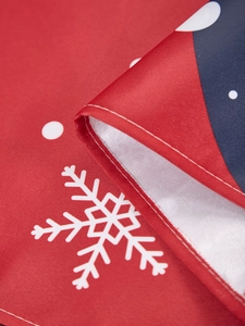Macro view of Christmas table runner fabric showing red snowflake patterns and fine stitching