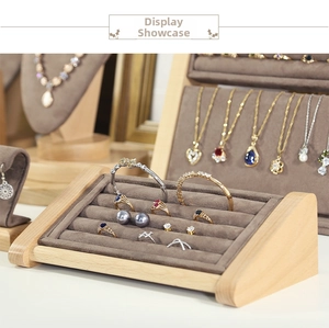 Detail showing solid wood jewelry display stands with grey velvet lining and elegant necklaces