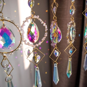 Crystal suncatcher with natural stones and prisms creating colorful rainbow light spots