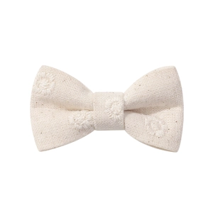 Close-up of cream cotton linen hair clip with delicate floral embroidery and textured fabric
