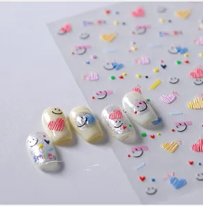 Vue macro détaillée de stickers nail art 5D avec cœurs pastel et motifs de sourires