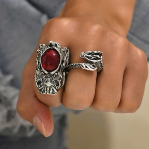 Detail of a vintage silver dragon double-finger ring featuring a central red gemstone