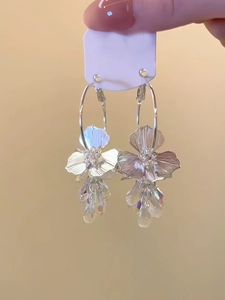 Détail macro de boucles d'oreilles fleurs en argent avec franges en cristal