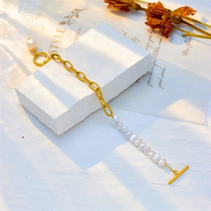 Punk style gold chain and pearl splice bracelet with OT toggle clasp on white stone