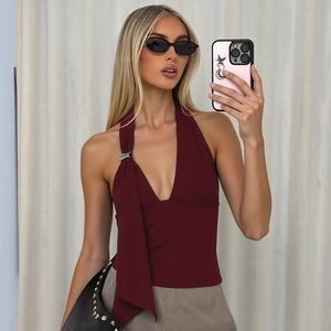 Detail of burgundy halter top with metal buckle and elegant draped fabric texture