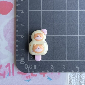 Detailed size view of a yellow cartoon cat resin popsicle charm on a measurement mat