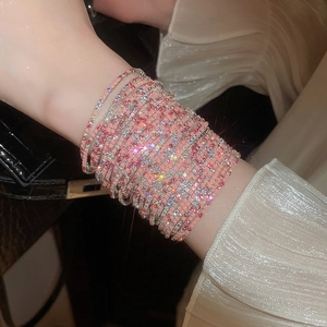 Macro shot of pink and silver rhinestone stretch bracelets layered on a wrist