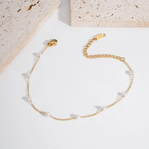 Close-up of double layer gold stainless steel anklet with small white pearls