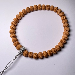 Macro view of Rudraksha beads texture with decorative silver metal pendant and carvings