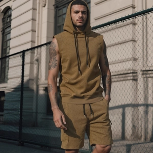 Men's khaki sleeveless hoodie and shorts sport set in a stylish urban outdoor setting