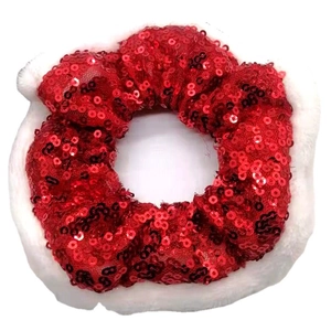 Festive red sequin scrunchie with white plush trim shown from a top-down angle