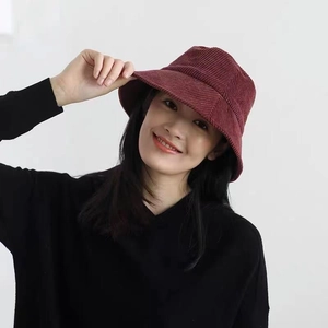 Detail of adjustable burgundy corduroy bucket hat shown on a model for style fit