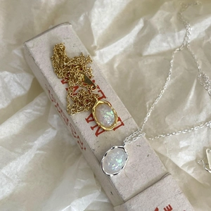 Detailed view of the oval opal pendant necklace with gold and silver bezel settings
