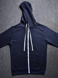Detail of dark blue zip-up hoodie featuring white drawstring and contrast zipper