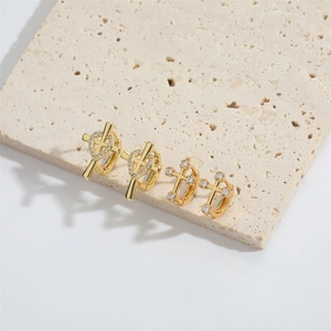 Exquisite gold floral heart and cross stud earrings set on a natural stone display
