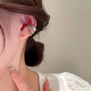 Detail of silver triple-layer ear cuff with heart pendant and sparkling zircons