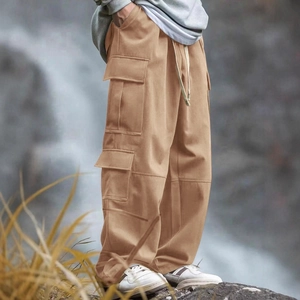 Men's loose fit multi-pocket khaki cargo pants with drawstring waist in outdoor setting
