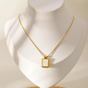 Collier vintage français doré avec pendentif rectangulaire en nacre sur buste blanc