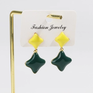 Detail of vintage gold-plated diamond-shaped studs with green and yellow clover enamel