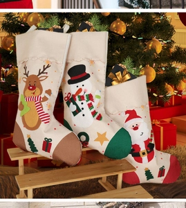 Detailed view of three vintage burlap Christmas stockings with elk and snowman embroidery