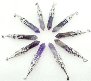 Macro shot of ten hexagonal amethyst pendants with silver floral caps on white background