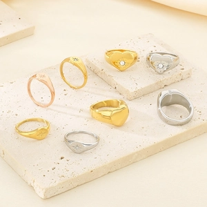Close-up of star and heart rings in gold, silver, and rose gold on a stone display