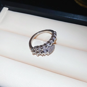 Macro shot of silver snake-shaped ring with pavé-set zircon stones in a jewelry box