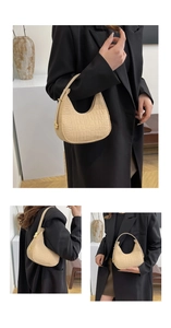 Detail of beige crocodile pattern felt bag with gold hardware shown on black blazer