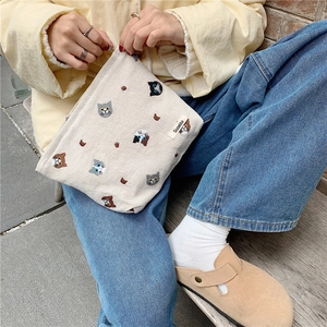 Close-up of cute cat head embroidery on a cream cotton linen canvas makeup bag
