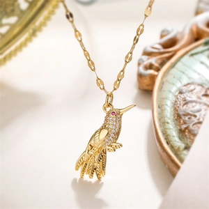 Détail macro du collier pendentif colibri doré avec sertissage en zircons brillants