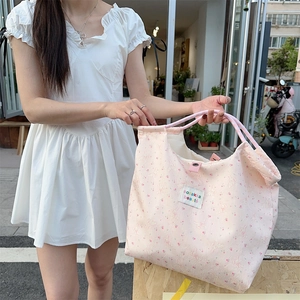Detail of pink canvas tote bag with cute cartoon rabbit and floral print patterns