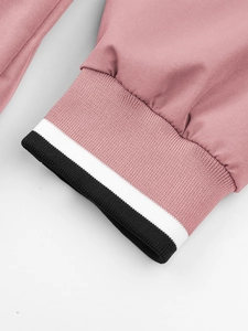 Detail van roze jas met zwart-wit gestreepte ribboorden voor windbescherming