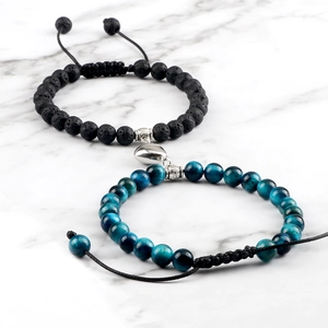 Close-up of magnetic heart connector on volcanic stone and blue tiger eye bracelets
