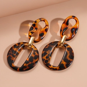 Macro detail of leopard print acrylic earrings with elegant golden metal connector loops